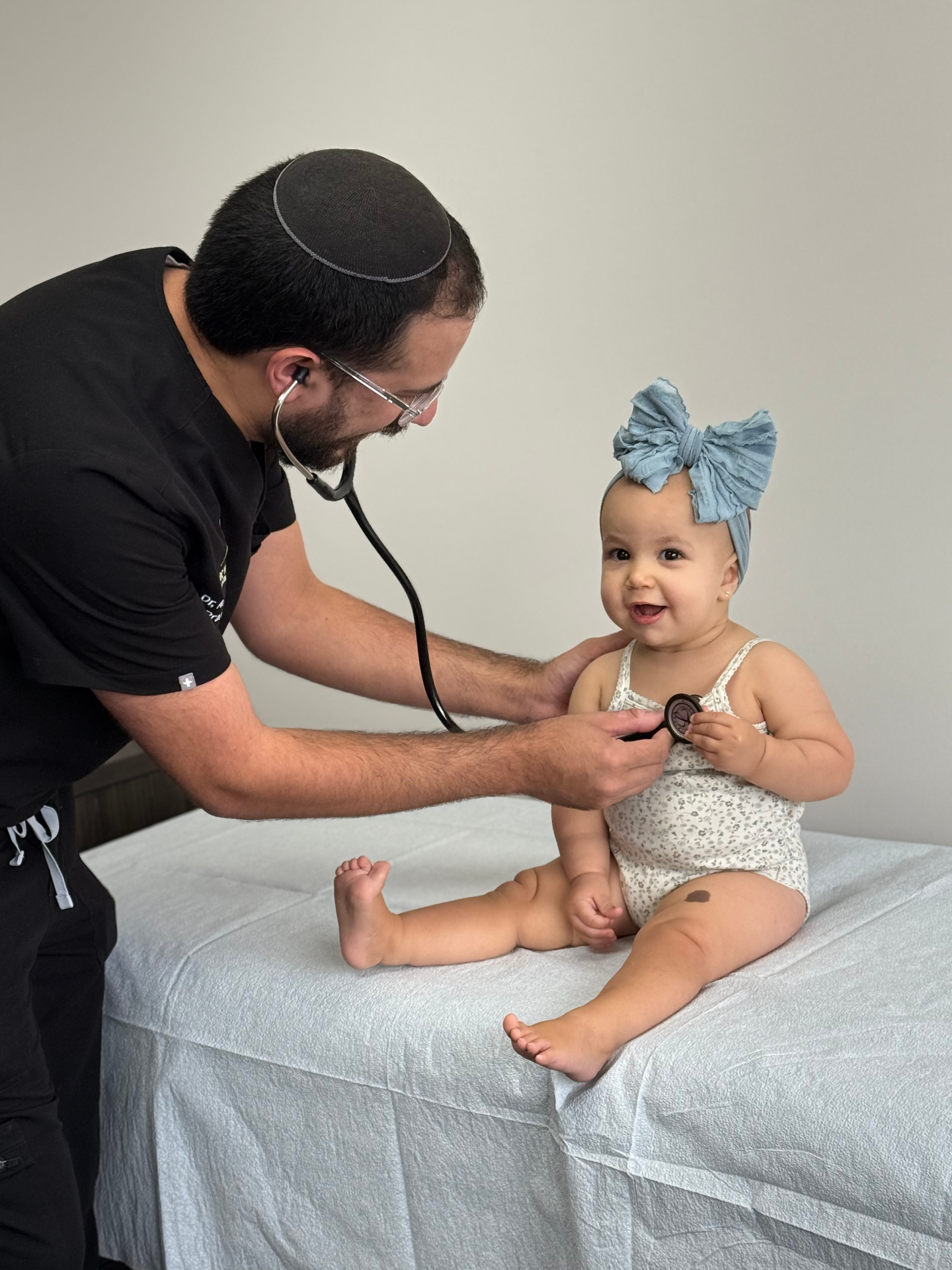 Clinician examining a baby with a stethoscope