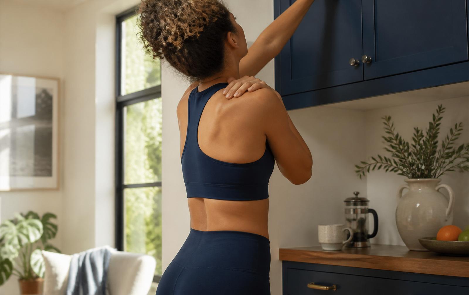 Active adult experiencing shoulder discomfort while reaching overhead